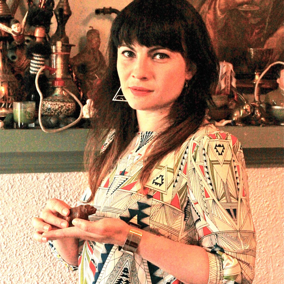 A dark haired woman holding the a bear shaped knickknack.
