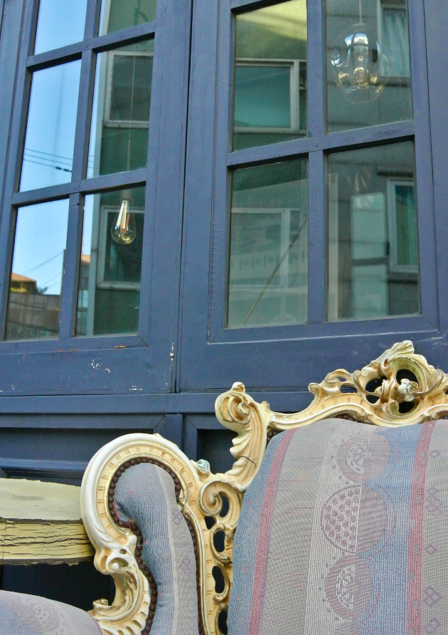 Right corner of a periwinkle, cobalt blue, and burgundy striped Queen Anne chair: A captivating blend of colors and patterns, highlighting the intricate design of the Queen Anne period.